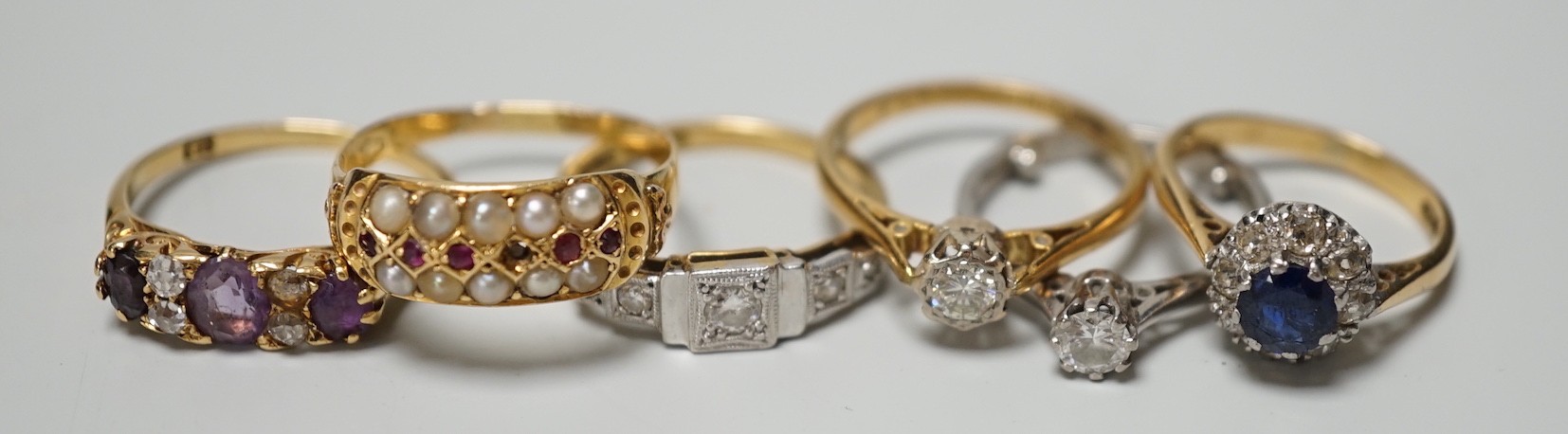 Five assorted 18ct and gem set rings, including 1920's millegrain diamond set, two solitaire diamond rings, sapphire and diamond cluster and amethyst and diamond half hoop (stone replaced and repair) and one other yellow